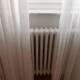 Lange gordijnen voor de radiator kunnen het convectieproces verhinderen